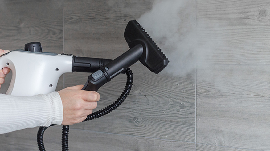 Czyszczenie kafelków za pomocą białej ręcznej myjki parowej.