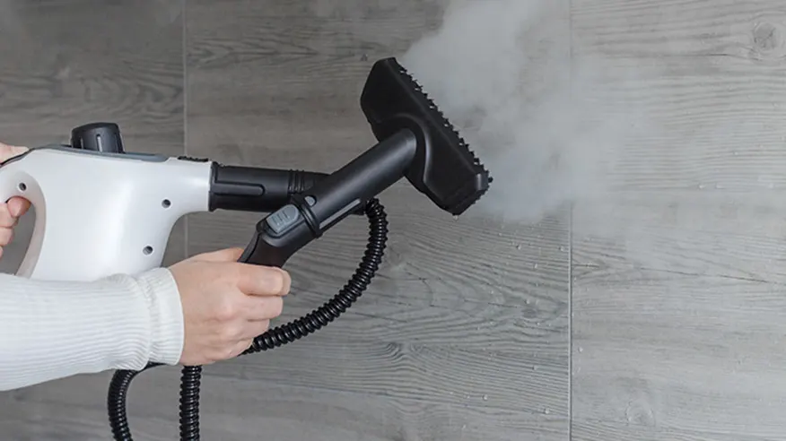 Czyszczenie kafelków za pomocą białej ręcznej myjki parowej.