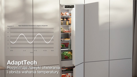 Biała lodówka z otwartymi drzwiami, wypełniona jedzeniem. Na drzwiach wykres i tekst AdaptTech.