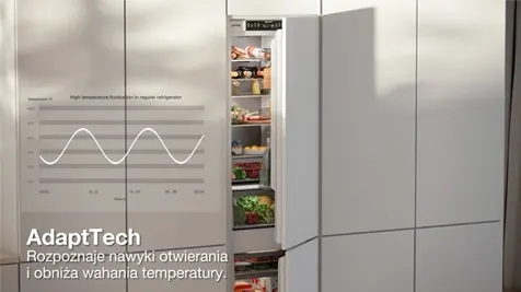 Biała lodówka z otwartymi drzwiami, wypełniona jedzeniem. Na drzwiach wykres i tekst AdaptTech.