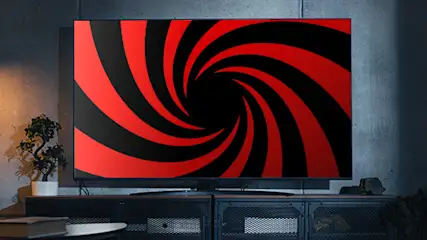 Telewizor na szafce w nowoczesnym salonie, wokół ramy neonowe oświetlenie.