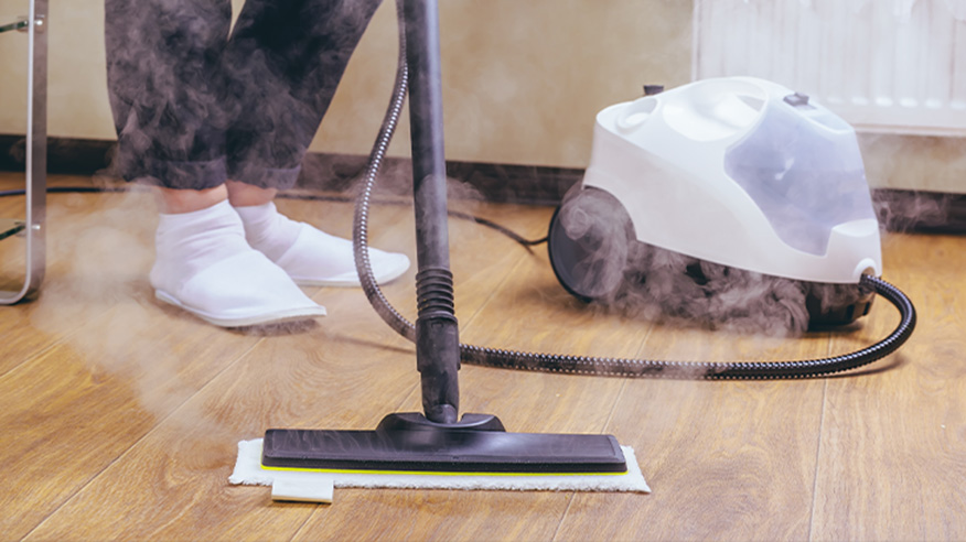 Osoba sprzątająca podłogę za pomocą myjki parowej z szeroką nakładką mopującą. 