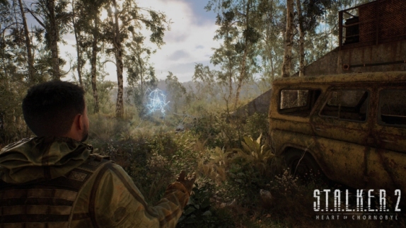 Mężczyzna w mundurze obserwuje niebieską anomalię w lesie. W tle widać zardzewiały pojazd i logo „S.T.A.L.K.E.R. 2”.