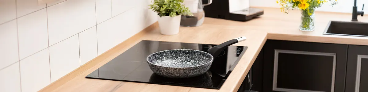 Patelnia stojąca na płycie indukcyjnej w kuchni.