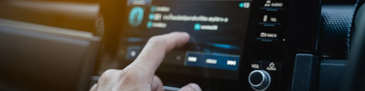 Palec dotyka ekranu dotykowego w aucie i włącza funkcje parowania telefonu z radiem samochodowym.