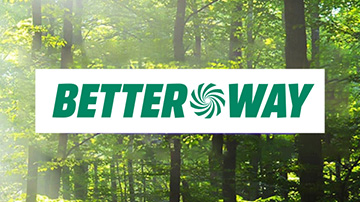 Na tle lasu widoczny jest biały prostokąt z zielonym napisem "BETTER WAY", gdzie litera "O" jest stylizowana na wir.