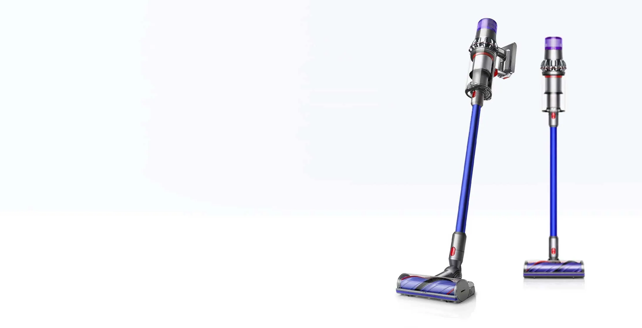 Dwa odkurzacze bezprzewodowe Dyson: jeden pionowo i jeden w pozycji roboczej. Oba są niebieskie ze srebrnymi i fioletowymi akcentami.