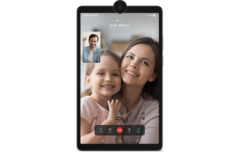 Tablet Galaxy Tab A11 podczas rozmowy wideo z trzema osobami, na ekranie widoczne imiona i opcje sterowania rozmową na dole, z powiększoną dziewczynką i dorosłą kobietą, które trzymają się za ręce.