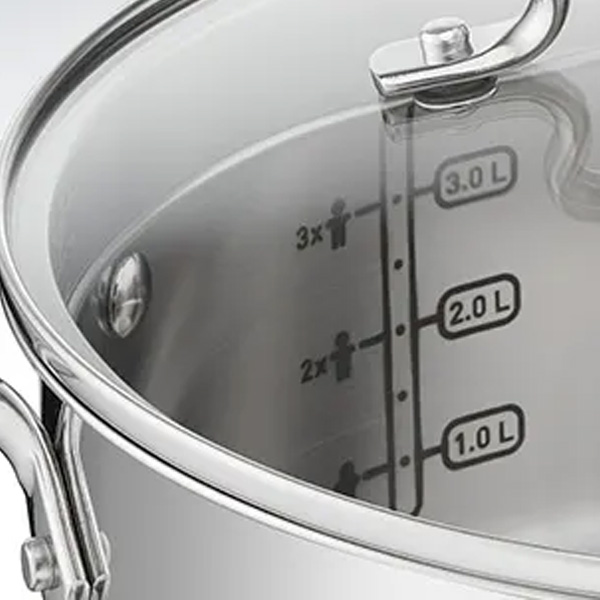 Zbliżenie na metalowy garnek z przezroczystą pokrywką. Na ściance wewnątrz widoczne oznaczenia litrażu od 1.0L do 3.0L.