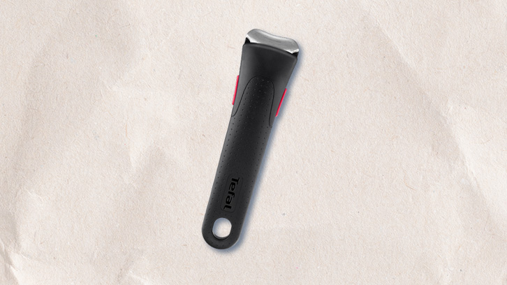 Czarny uchwyt Tefal z metalowym mocowaniem i czerwonymi akcentami na teksturowanym, kremowym tle.