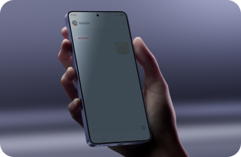 Ujęcie dłoni trzymającej smartfon na fioletowym tle; na ekranie otwarty czat z serduszkami i naklejką kota. zaciemnione za pomocą funkcji privacy display