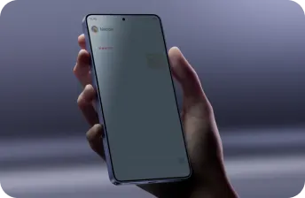 Ujęcie dłoni trzymającej smartfon na fioletowym tle; na ekranie otwarty czat z serduszkami i naklejką kota. zaciemnione za pomocą funkcji privacy display