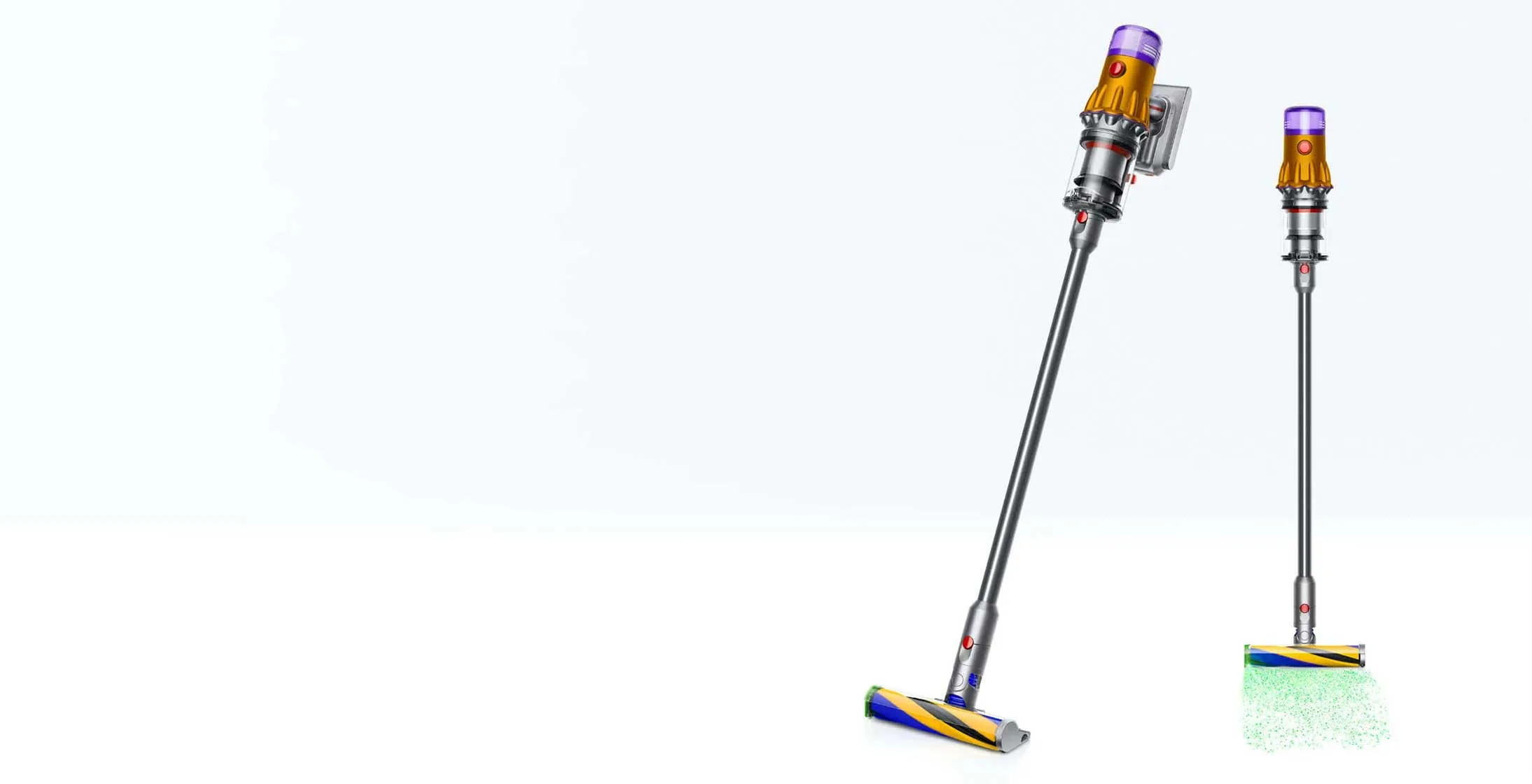 Dwa odkurzacze bezprzewodowe Dyson na białym tle. Jeden jest oparty o ścianę, drugi stoi pionowo z zieloną poświatą.