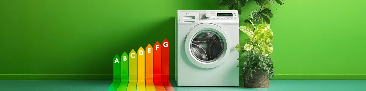 Biała pralka stojąca przy grafice pokazującej klasy energetyczne.