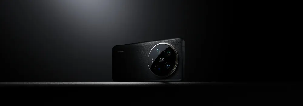 Na ciemnym tle leży czarny smartfon z okrągłym modułem aparatu z napisem LEICA.