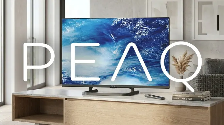 Telewizor w salonie, stojący na komodzie. Na tym wielkie białe LOGO PEAQ.