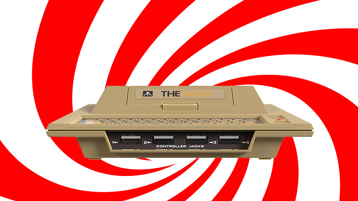 Beżowa konsola do gier z napisem "THE" na tle białych i czerwonych spiralnych pasów.