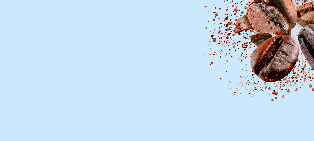 Na jasnoniebieskim tle unoszą się brązowe ziarna kawy i drobne brązowe cząsteczki, tworząc dynamiczną kompozycję w prawym górnym rogu.
