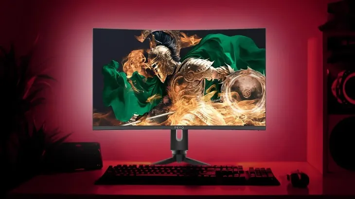 Na zdjęciu widoczny jest monitor z grafiką rycerza, klawiatura i mysz na biurku, wszystko w czerwonym oświetleniu.