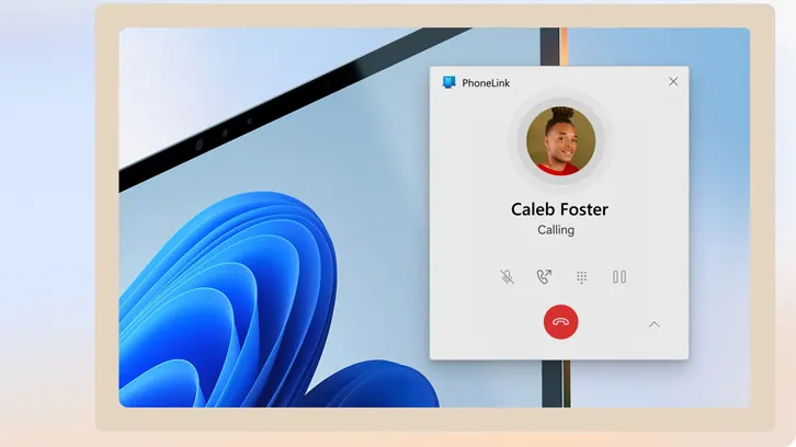 Ekran komputera pokazuje okno PhoneLink z połączeniem od Caleba Fostera na tle tapety Windows z niebieskim motywem.