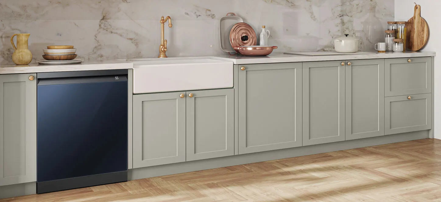 Blat kuchenny z szarą zabudową, zlewem i złotą armaturą. Na blacie naczynia i akcesoria kuchenne. Widoczna zmywarka.