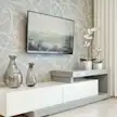 Dwa wazony, telewizor i dwa kwiaty na stoliku na tle ściany z wzorem i zasłony.