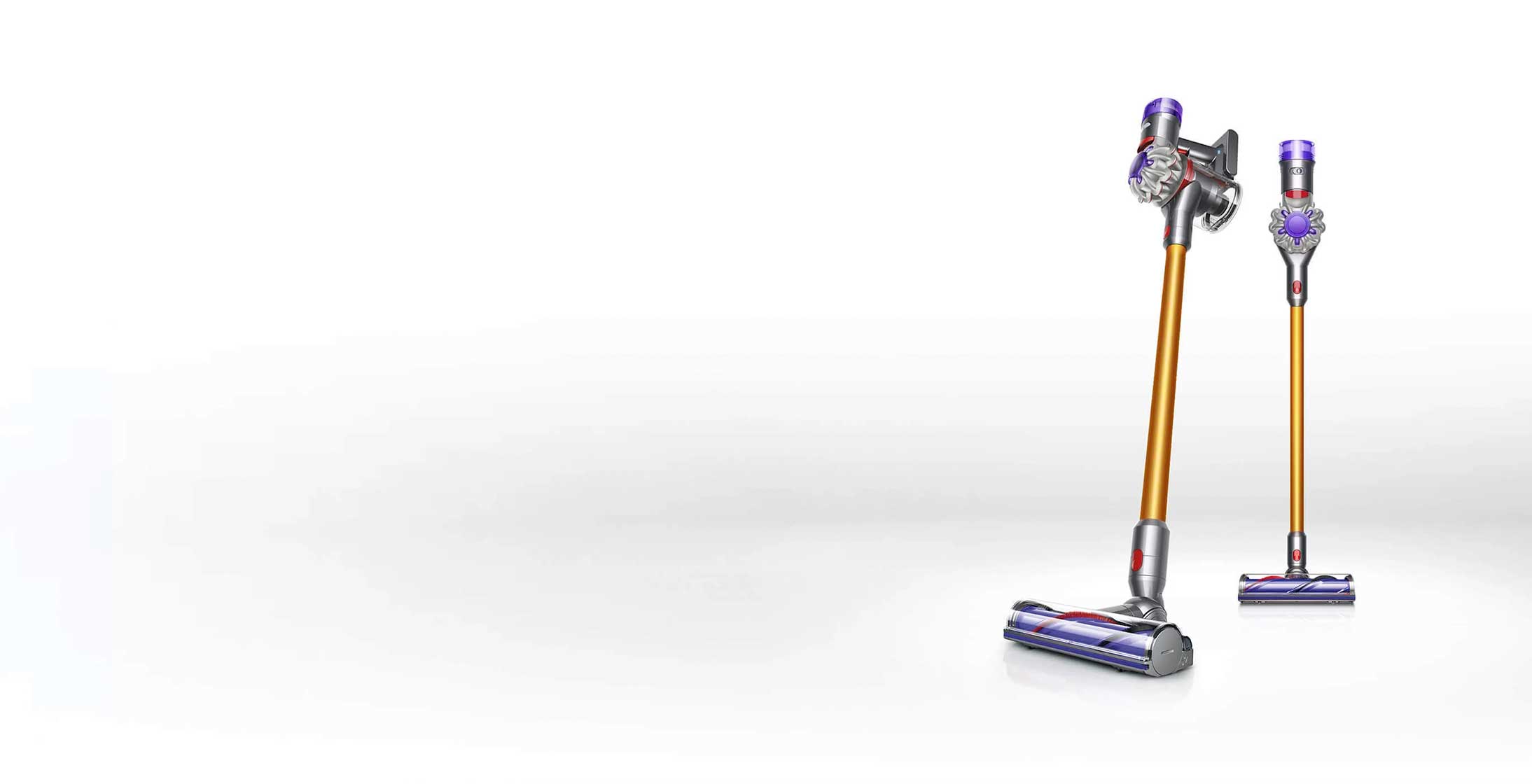 Dwa odkurzacze bezprzewodowe stoją na białym tle. Odkurzacze mają srebrne, fioletowe i złote elementy.