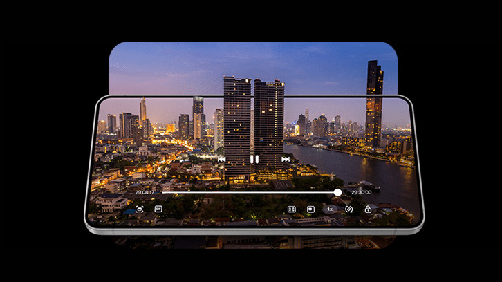Na czarnym tle widoczny jest smartfon, na którego ekranie wyświetla się nocny widok na miasto z rzeką i wieżowcami.