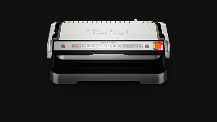 Na czarnym tle widoczny grill elektryczny marki Tefal w kolorze srebrno-czarnym, z panelem sterowania na froncie.