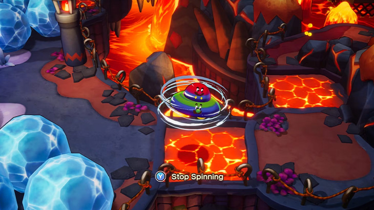 Kolorowa postać wiruje nad lawą w grze wideo. W tle widać kaskady lawy i kryształowe formacje.