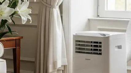 Elegancki pokój z klimatyzatorem przenośnym z rankingu podłączonym rurą do okna.