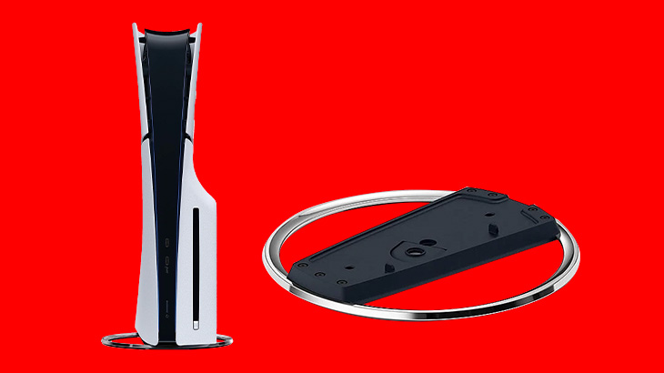 Na czerwonym tle widać biało-czarną konsolę do gier z podstawką i czarny kontroler w srebrnej obręczy.