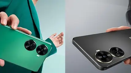 Dwa telefony w rękach. Zielony telefon z dwoma okrągłymi obiektywami i srebrnym logo oraz czarny telefon z dwoma okrągłymi obiektywami i złotym logo.