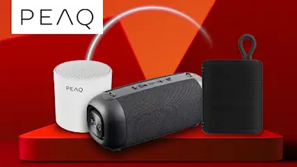 Na czerwonym tle znajdują się trzy głośniki i logo PEAQ. Dwa głośniki są białe, jeden czarny, wszystkie stoją na czerwonym podeście.