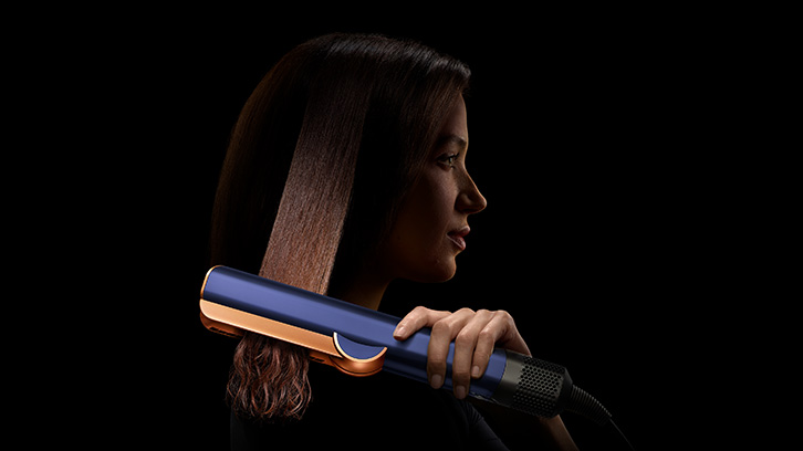 Modelka prostująca włosy prostownicą Dyson Airstrait