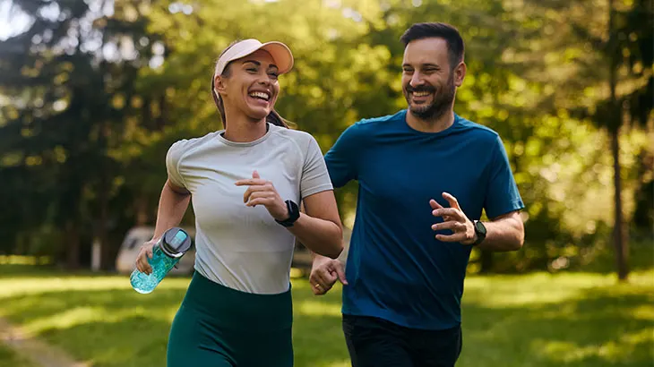 Kobieta i mężczyzna biegający po parku.
