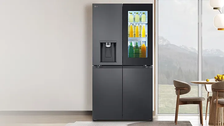 Lodówka pełna napojów stojąca przy ścianie