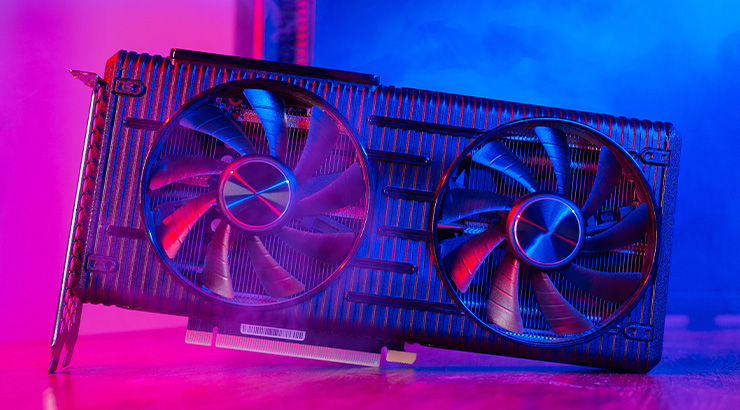 Karta graficzna z dwoma wentylatorami na tle niebiesko-różowym. Widoczne żeberka chłodzące i złącza karty.