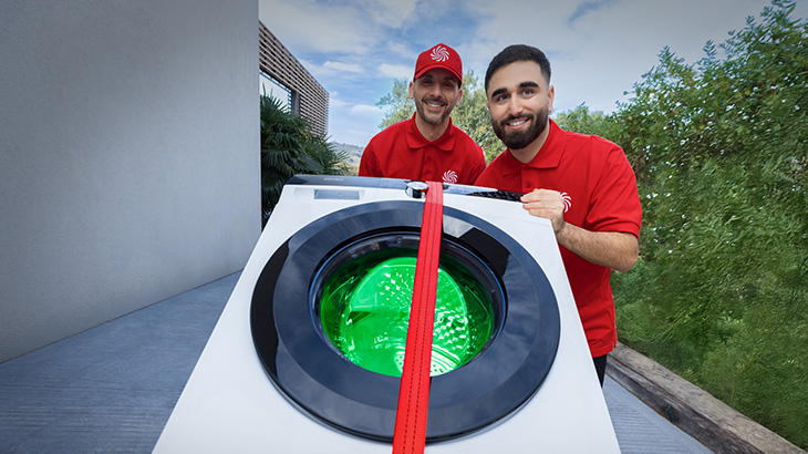 Dwóch mężczyzn w czerwonych koszulkach realizujący dostawę pralki