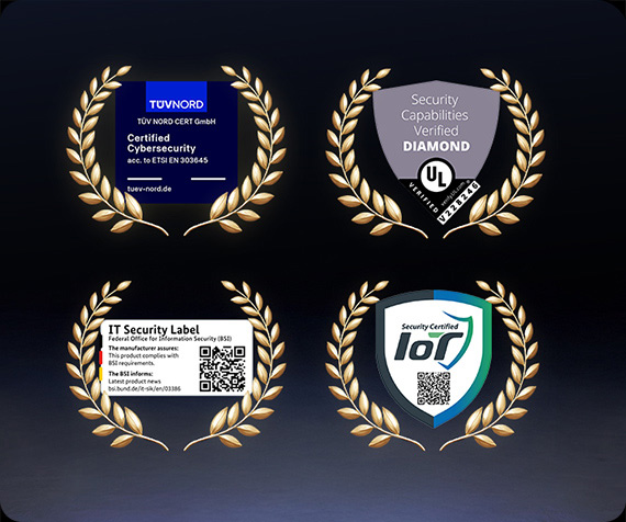Cztery odznaki certyfikatów cyberbezpieczeństwa na ciemnym tle, każda w złotym wieńcu: TÜV NORD – Certified Cybersecurity (ETSI EN 303 645); UL Verified – Security Capabilities, poziom Diamond; BSI – IT Security Label z kodem QR; IoT Security Certified – tarcza z kodem QR.