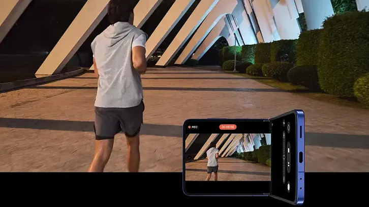 Mężczyzna biegnący nocą, obok smartfon Flip 7 nagrywający film