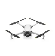 Biały dron z czterema śmigłami na białym tle. Widoczny obiektyw kamery na środku drona.