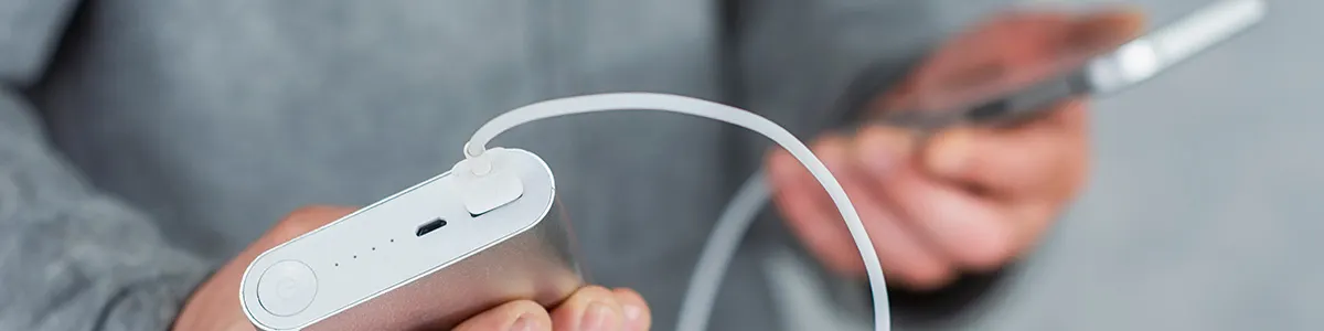 Powerbank z przewodem podłączonym do iPhone 