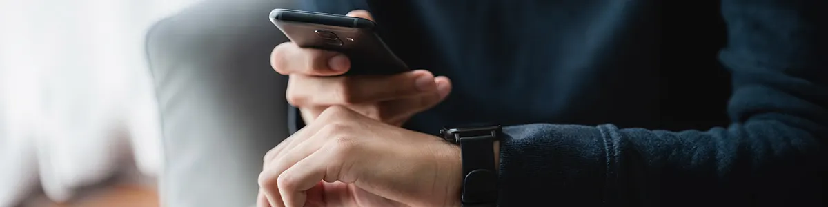 Mężczyzna parujący swój smartwatch z telefonem.