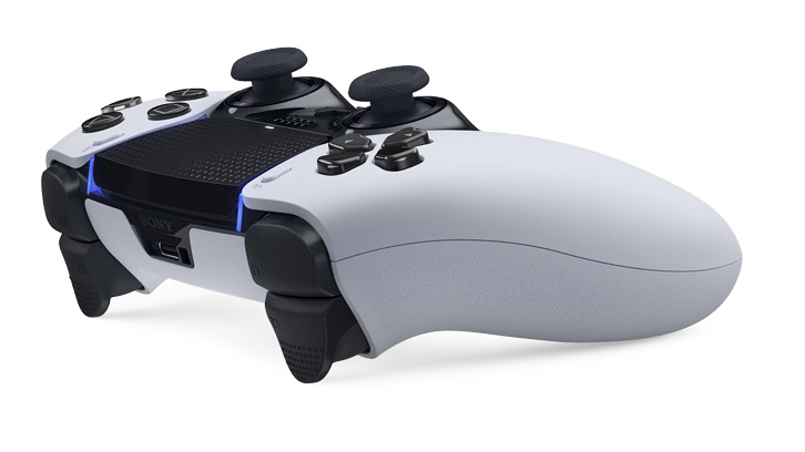 Biało-czarny kontroler do gier z czarnymi przyciskami i joystickami, leżący na białym tle.