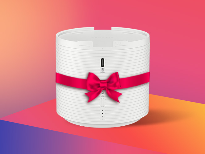 Biały, cylindryczny powerbank z poziomymi żłobieniami, przewiązany różową wstążką z kokardą; z przodu port USB‑C i diody, na kolorowym gradientowym tle.