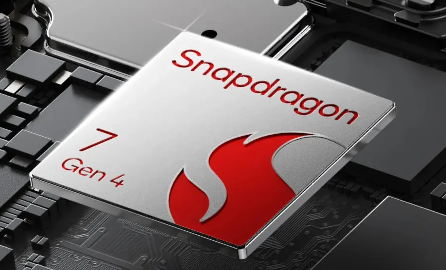 Procesor Snapdragon 7 Gen 4 z charakterystycznym, czerwonym logo płomienia na srebrnej obudowie. Procesor umieszczony jest na tle płyty głównej z widocznymi układami elektronicznymi i połączeniami.