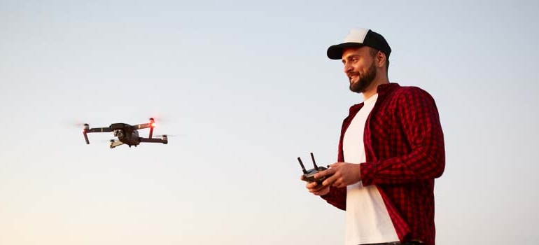 Mężczyzna sterujący filmującym dronem