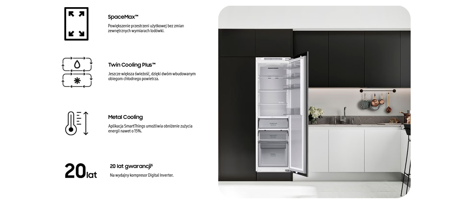 Lodówka z otwartymi drzwiami w kuchni. Szafki czarne i białe. Wiszące garnki i kwiaty na blacie.