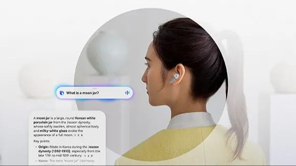 Osoba z kucykiem, twarz rozmyta, ma w uchu białą słuchawkę Buds4 pro; nad ramieniem widoczny pasek asystenta z pytaniem „What is a moon jar?” oraz po lewej karta z tekstową odpowiedzią; jasne, minimalistyczne tło.